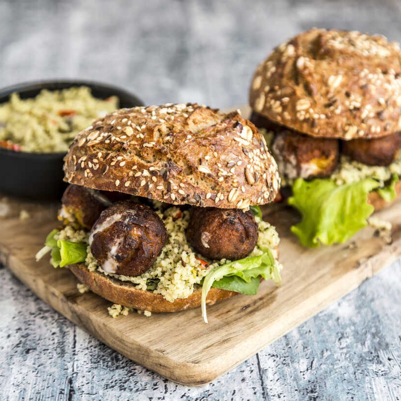 Hamburguesa libanés: patty de falafel, hummus remolacha, tomate, espinacas baby, tzatziki, pan brioche (V)